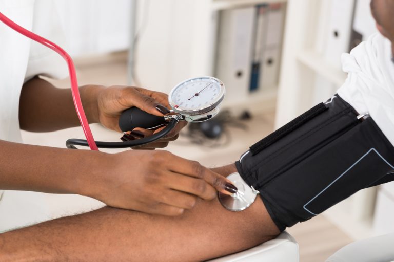 Nurse taking high blood pressure of a man